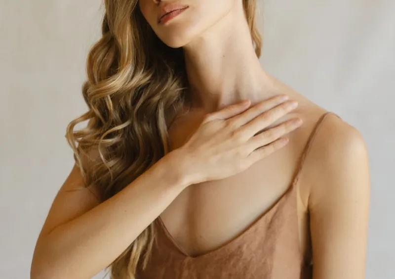 Mujer aplicando cuidado corporal en cuello y escote.